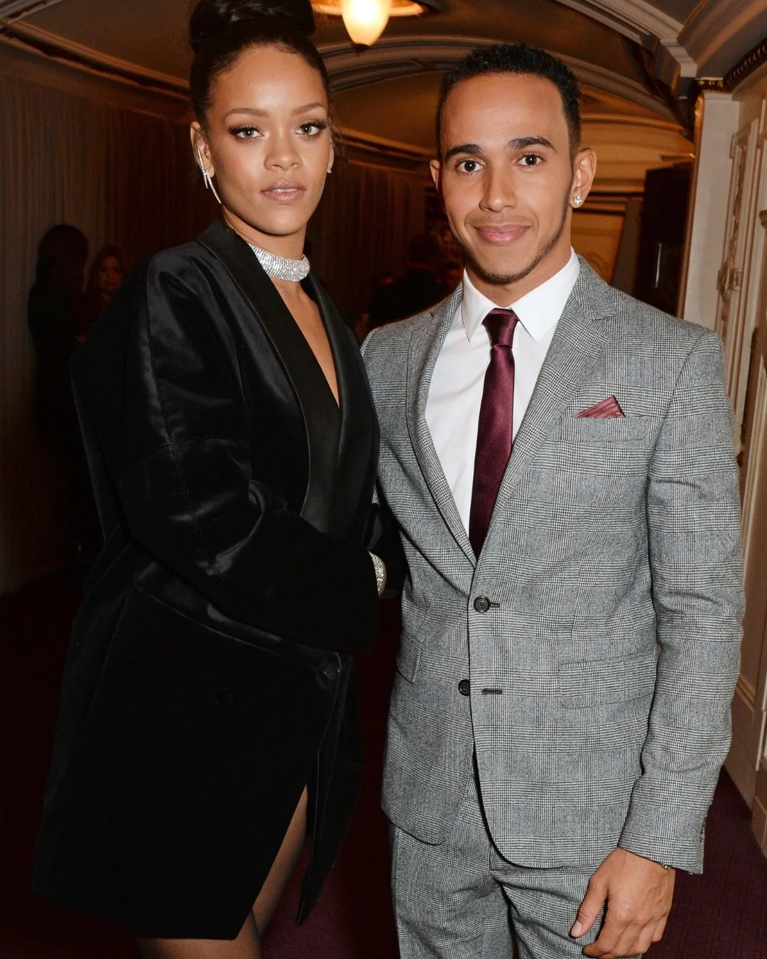 A man and woman wearing formal attire smiling. 