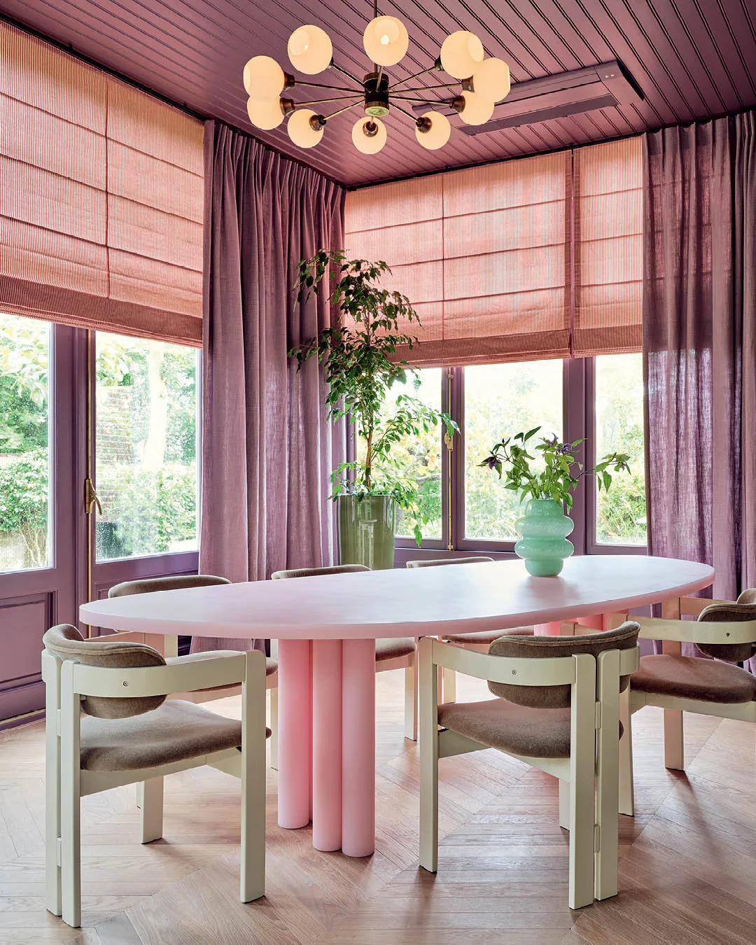 A purple and pink living room with a white dining table. 