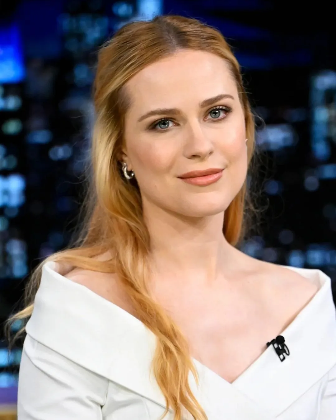 A blonde woman wearing a white shirt smiling.