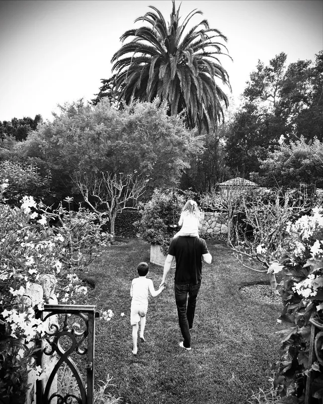 a black and white photo of prince harry and his children in their garden