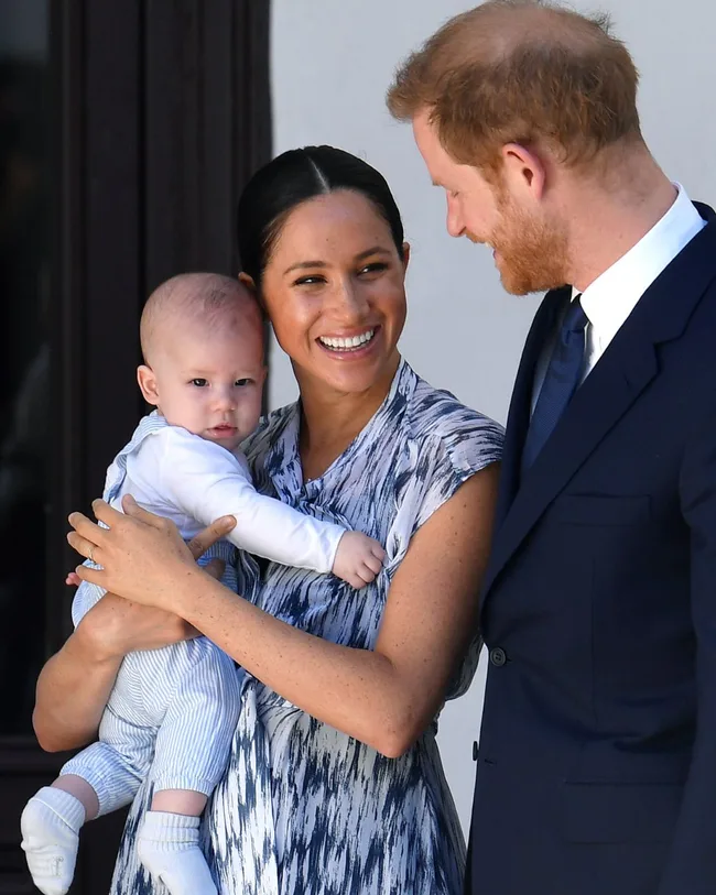 meghan smiles with prince harry and their infant son archie