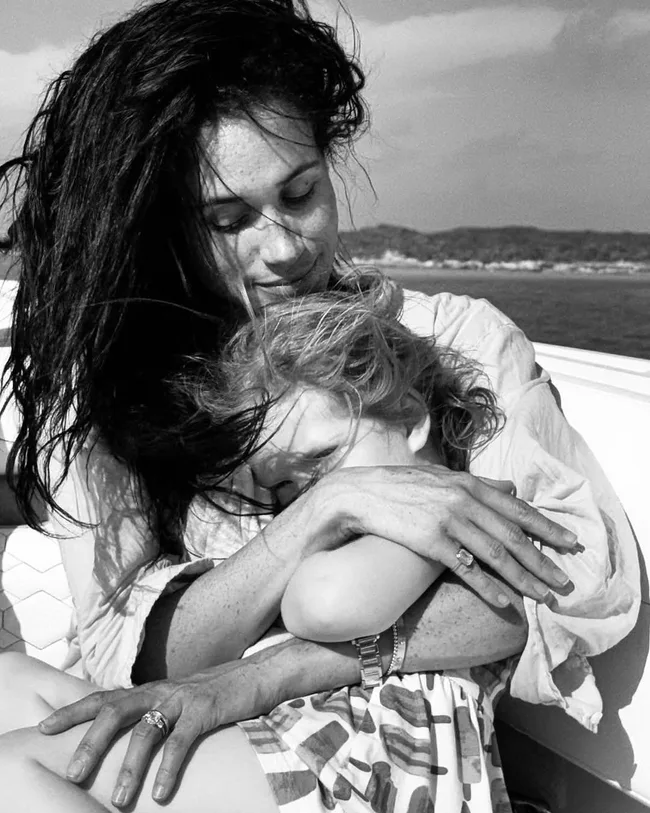 meghan cradles four-year-old daughter lilibet as the wind sweeps their hair