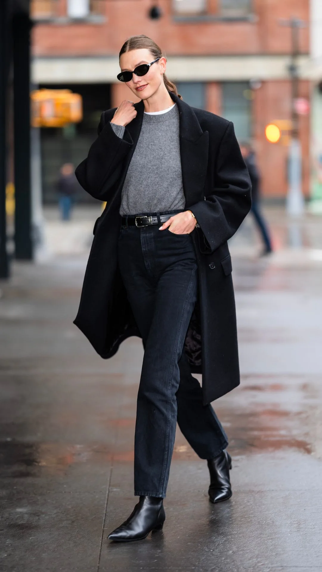 karlie kloss wearing black ankle boots jeans and a grey sweater
