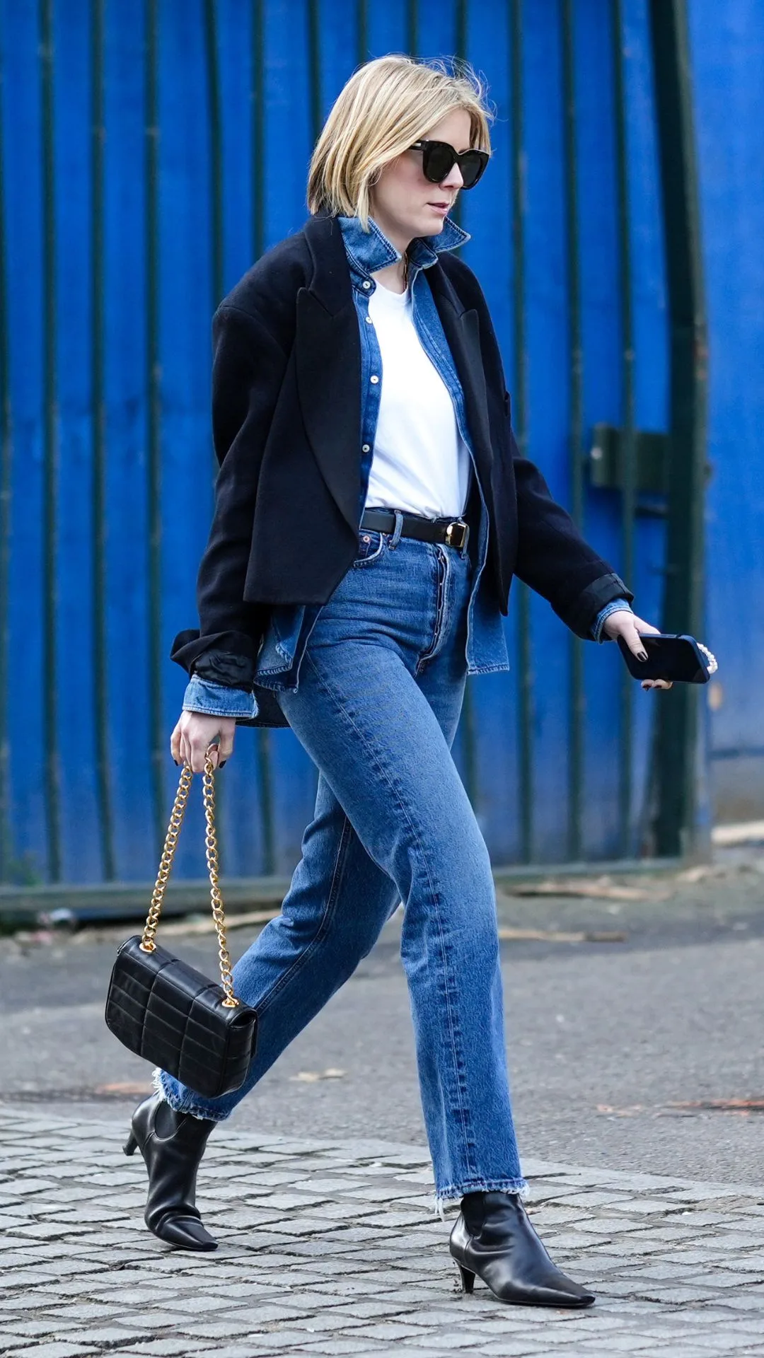 woman wears black pointed toe ankle boots with blue jeans, white tshirt and black jacket