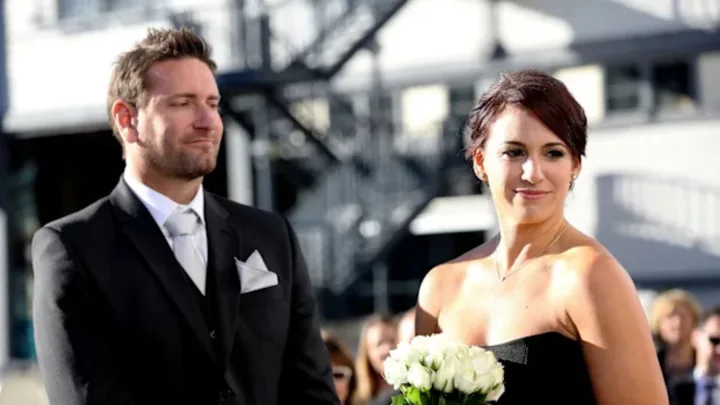 Lachlan Rofe, as seen in a still for Married At First Sight Australia. Dressed in a black suit.