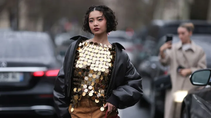 what to wear to a concert example of woman in gold top and leather jacket