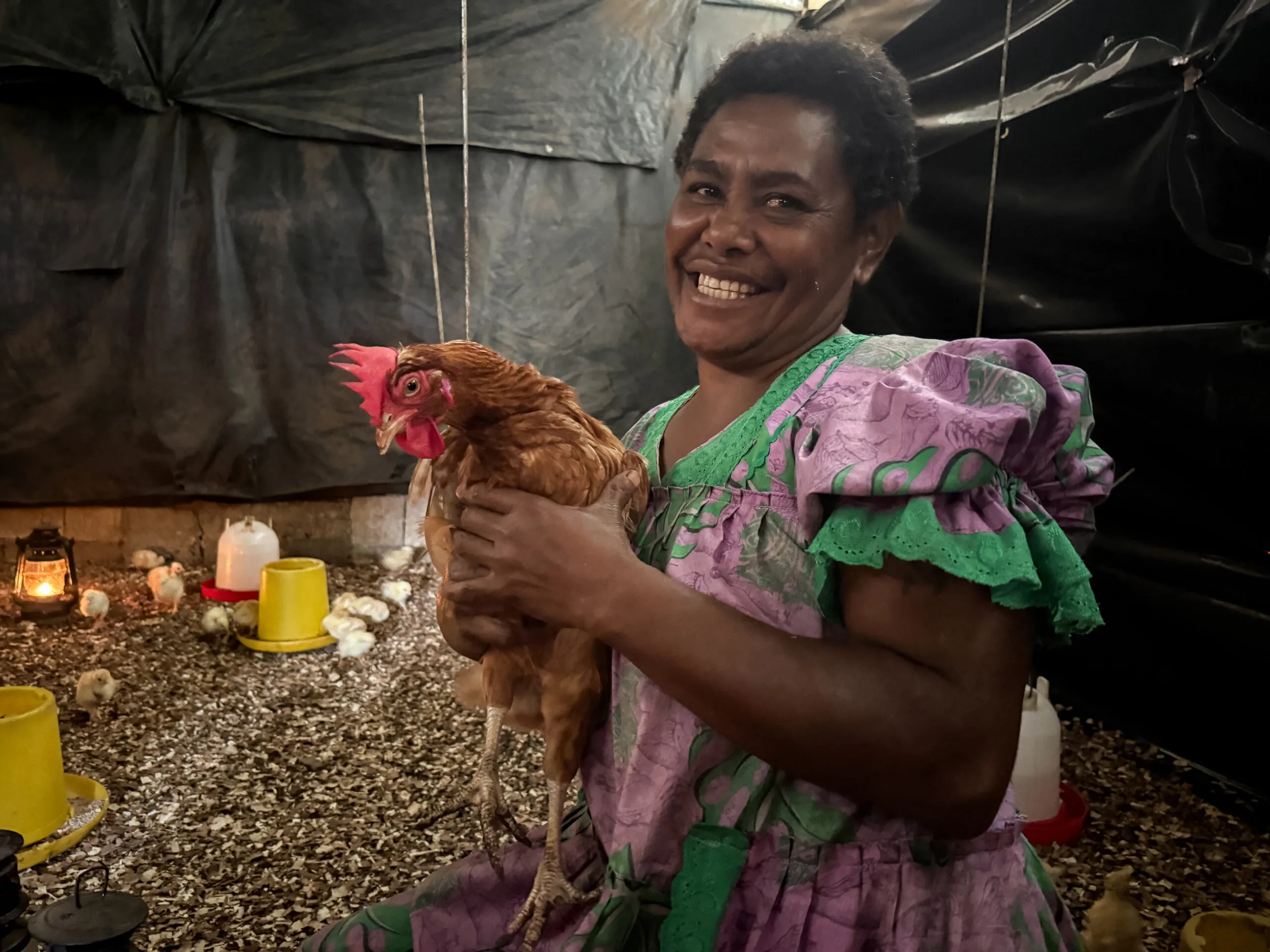 Credit: © Harriet Pratten / ActionAid. Rita Kaltonga (East Efate Community, Mobiliser WITTT ) holds one of her hens. Mama’s Chicken Farming Efate in Epau village, Efate.