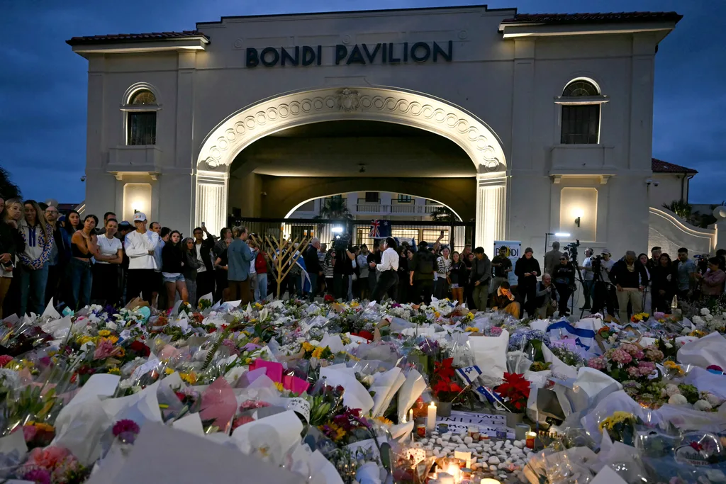 Mourners gather at a tribute at the Bondi Pavillion in memory of the victims of a shooting at Bondi Beach, in Sydney on December 15, 2025. A father and son opened fire on a Jewish festival at Australia's Bondi Beach in a shooting spree that killed 15 people, including a child, authorities said on December 15, denouncing the attack as antisemitic "terrorism". (Photo by Saeed KHAN / AFP via Getty Images)