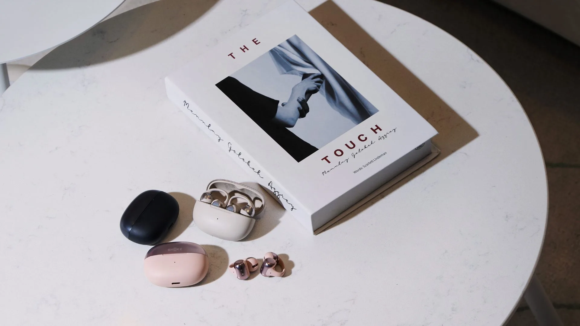 Shokz OpenDots ONE earbuds in grey, black and pink