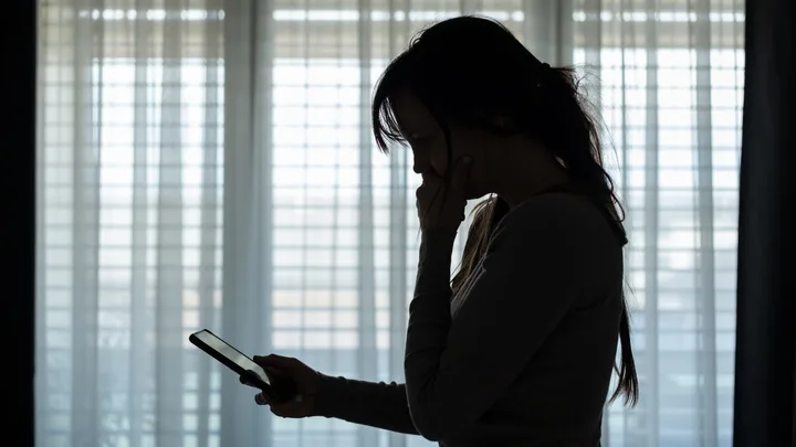 woman looking at phone in the dark