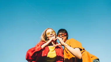 two women making a love heart