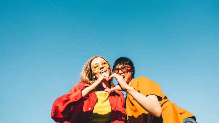 two women making a love heart