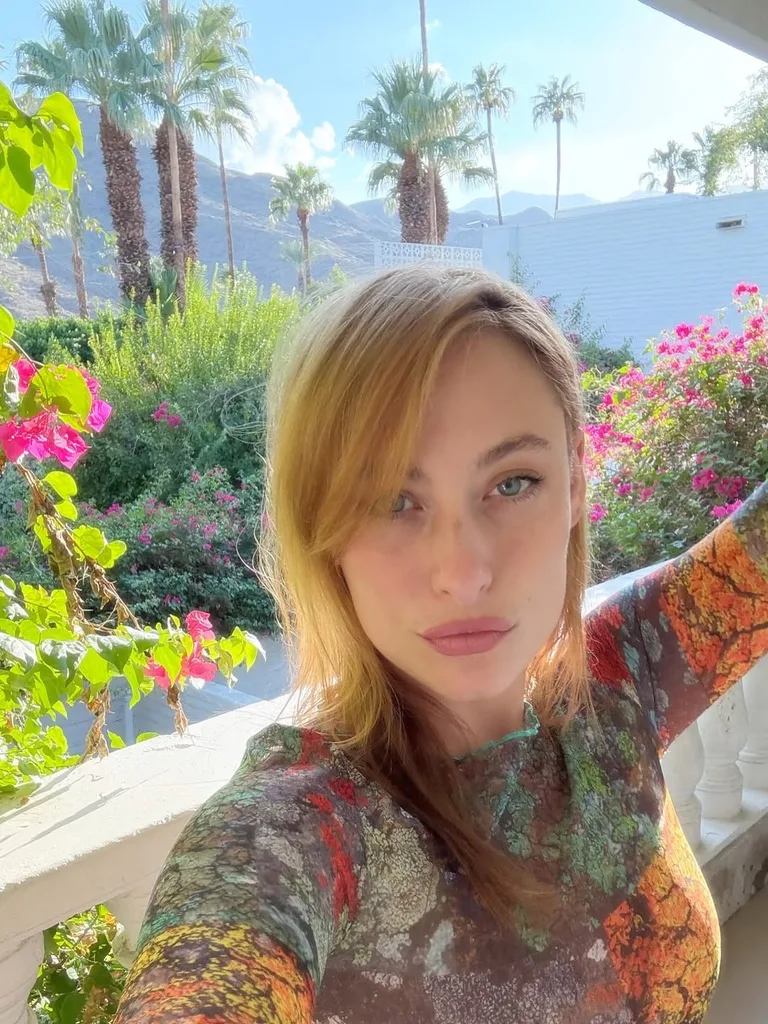 Nick Robinson's rumoured girlfriend Samantha Urbani posing for a selfie with a bougainvillea backdrop