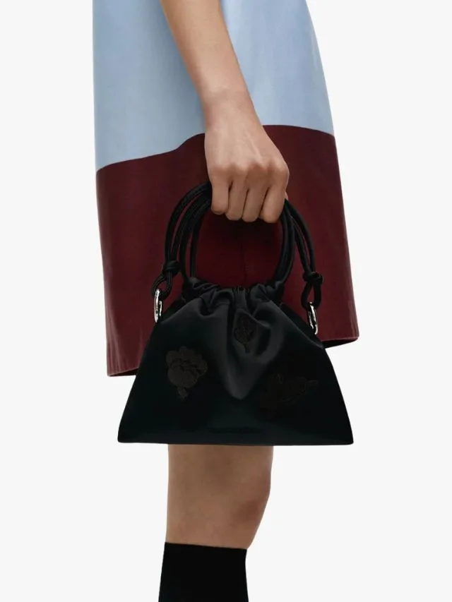 Marimekko Black satin pouch bag held by women in side profile