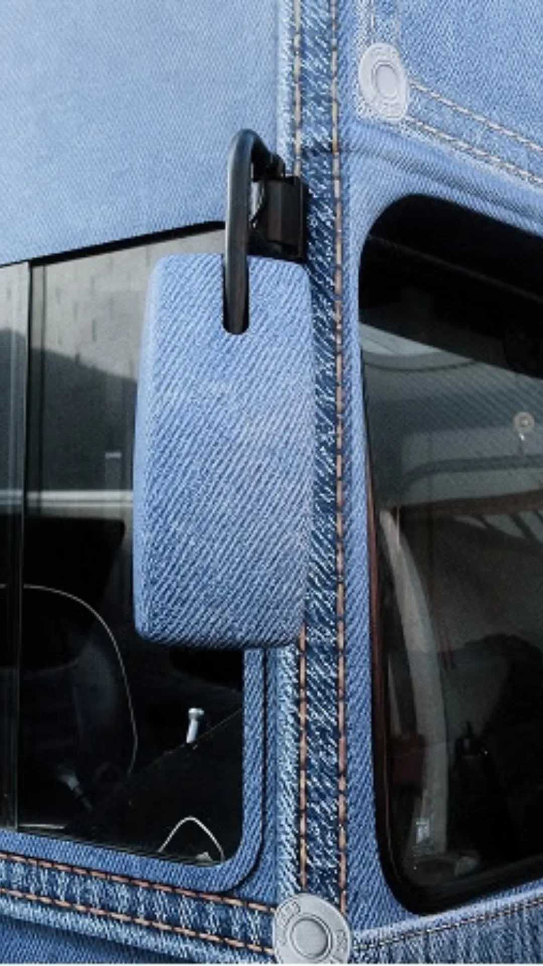 A bus window covered in denim print.