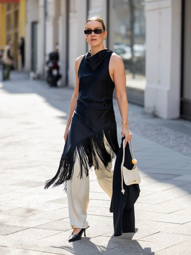 Woman at fashion week shows how to wear elastic waist pants in white satin at fashion week