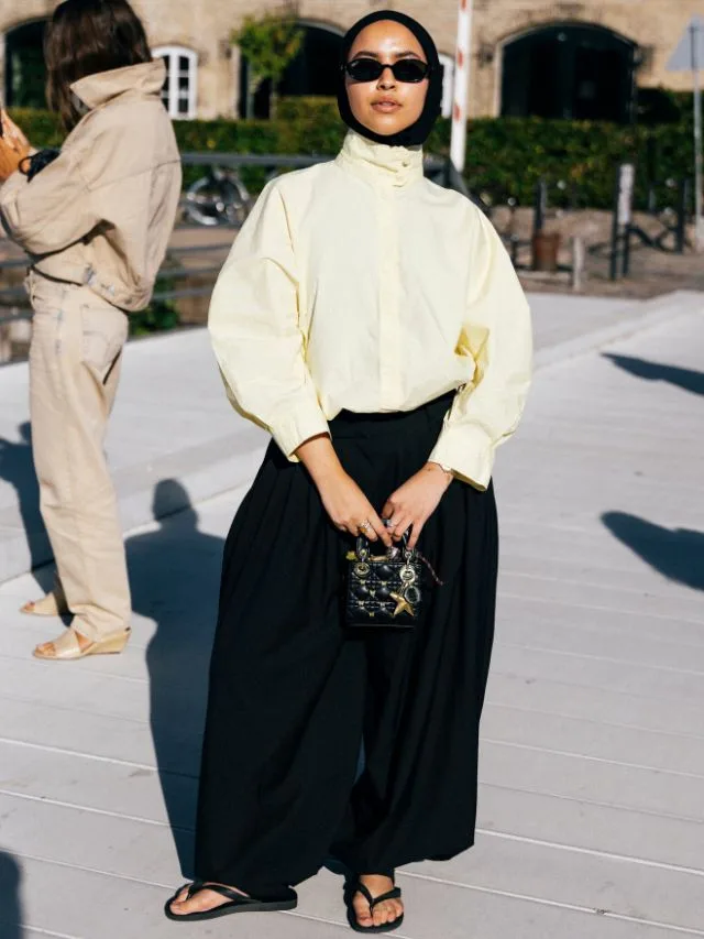 Woman wears light yellow hued windbreaker for summer fashion week in Copenhagen