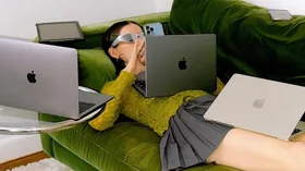 woman on green couch with multiple devices to online shop