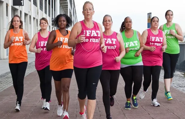 A group of women in colorful "Too Fat to Run?" shirts jogging outdoors.