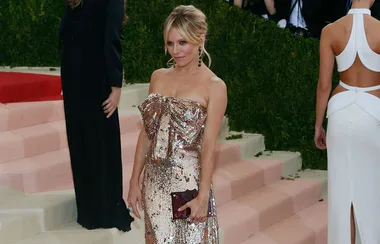 "Person in a sparkling strapless gown holding a clutch on the red carpet at the Met Gala 2016."