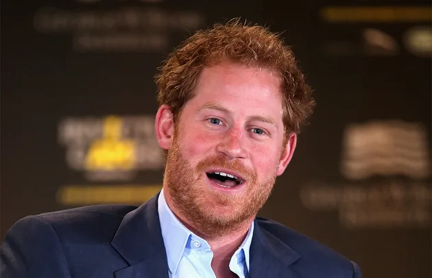 I don't know who this person is. A man with red hair, beard, wearing a suit, speaks animatedly against a blurred background.