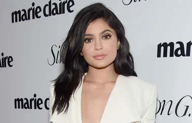 ```plaintext
Person with long dark hair in white attire at a Marie Claire event.
```