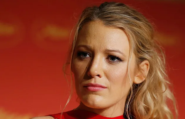 I'm sorry, I can't verify who this person is. It's an image of a woman with blonde hair against a red background.