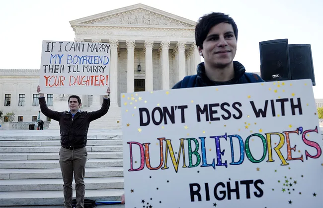 Protesters outside a court hold signs supporting same-sex marriage with humorous messages about marriage equality.