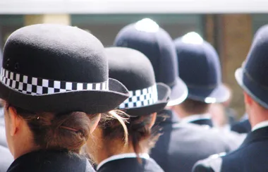 Police officers in uniform attending a public event, wearing traditional checkered hats.