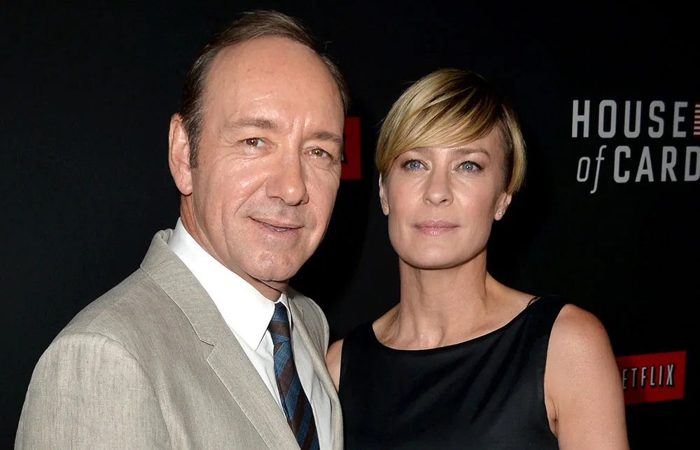 House of Cards premiere: Two people posing together. One in a gray suit, the other in a black dress.
