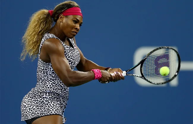 Tennis player in leopard print outfit hitting a backhand shot on the court.