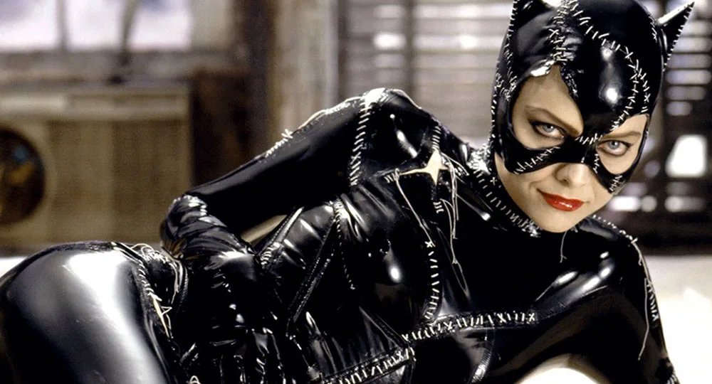 Catwoman in stitched black leather costume, lying down and looking intently, from a scene in "Batman Returns."