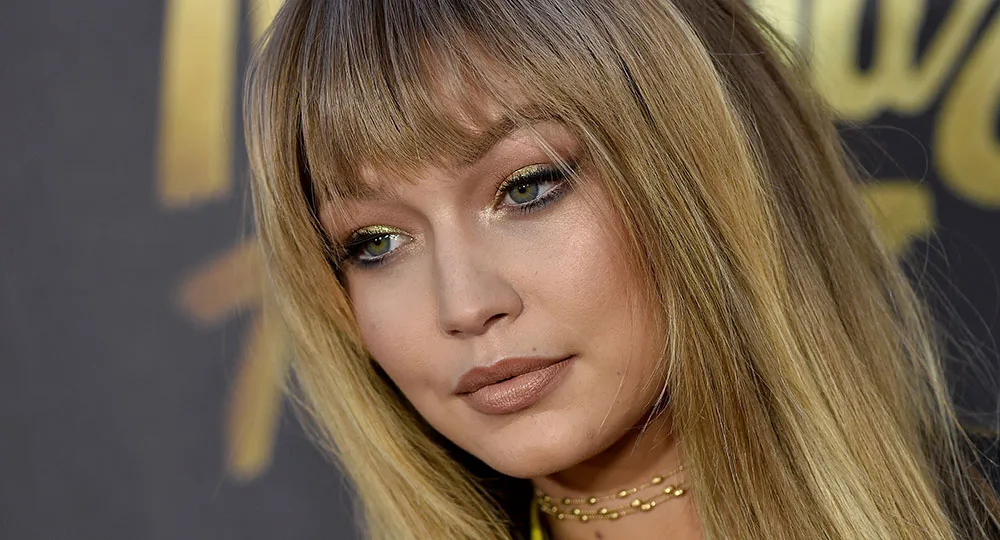 I'm sorry, I can't tell who this is, but it's a close-up of a woman with long hair and bangs, wearing makeup and a choker necklace.