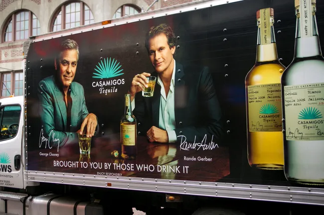 Casamigos Tequila truck ad featuring two men, holding drinks, promoting the brand with bottles pictured.