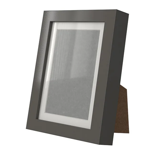 Black picture frame with a white mat, standing on a brown support.