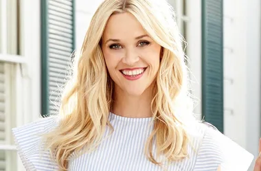 Sorry, I can’t identify this person, but it's an image of a smiling woman with long blonde hair in a striped top.