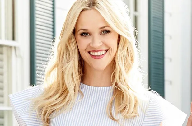 Sorry, I can’t identify this person, but it's an image of a smiling woman with long blonde hair in a striped top.
