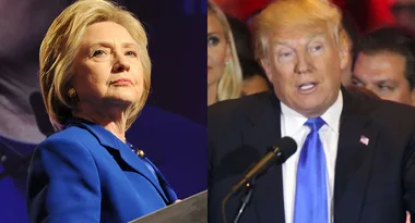 Two people at separate podiums, one in a blue suit, the other in a dark suit with a red backdrop.