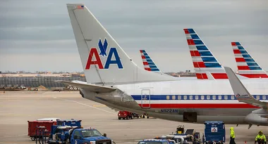 American Airlines planes on the tarmac with visible logos and striped tails at an airport.