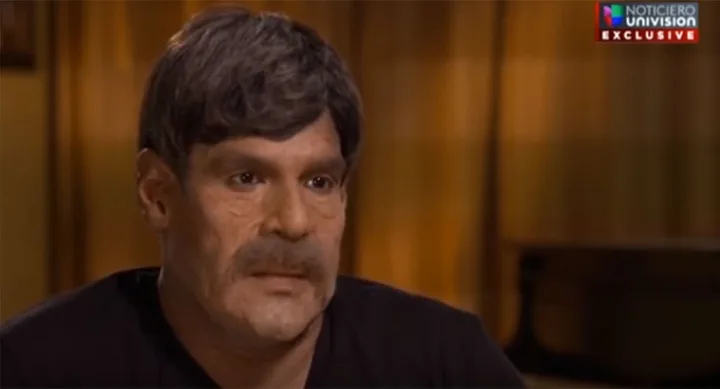A man with a moustache and short hair in a TV interview setting, with "Noticiero Univision Exclusive" on screen.