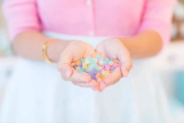 Hands holding colorful Japanese sugar candies in a soft focus.