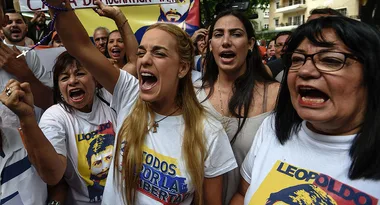 Protesters rally with "Leopoldo" shirts and banners, expressing support and chanting energetically in a crowd.