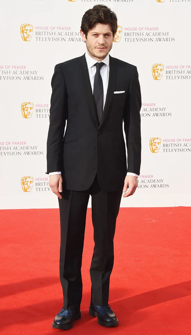 Man in a black suit on a red carpet at the British Academy Television Awards event.