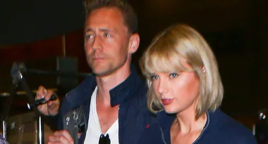 Two people walking together, one with short blonde hair. They appear to be in a casual setting.