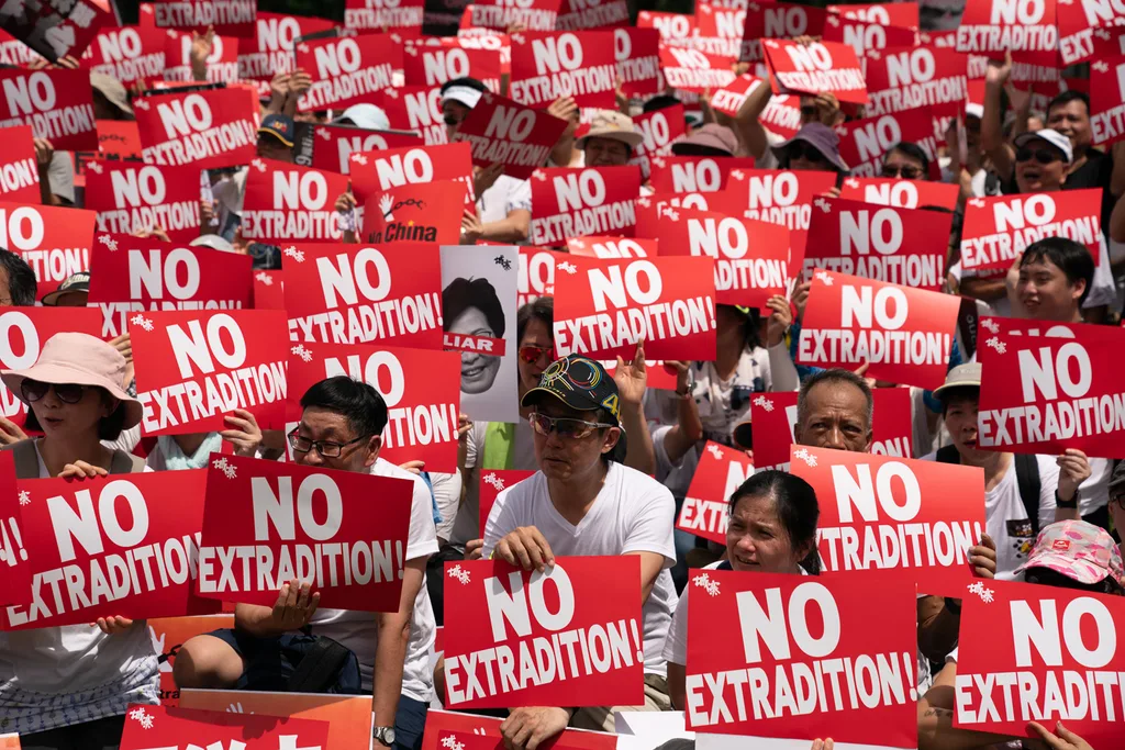 rotesters hold placards and shout slogans during a rally against the extradition law proposal on June 9, 2019 in Hong Kong