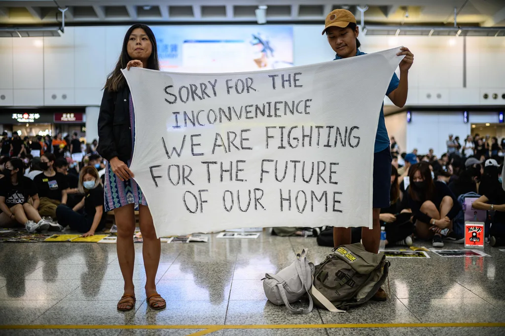 Protesters hold up a banner as they rally against a controversial extradition bill at Hong Kong's international airport on August 9, 2019.