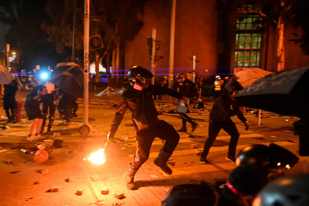 A protestor throws a petrol bomb during clashes with police outside the Polytechnic University of Hong Kong in Hung Hom district of Hong Kong on November 16, 2019.