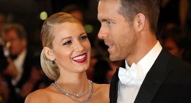 Two people dressed formally at a glamorous event, smiling and engaged in conversation.