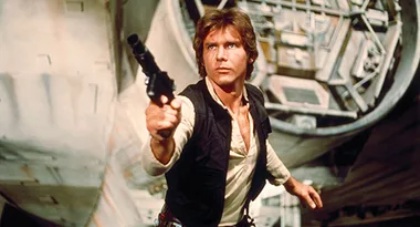 Han Solo aims a blaster in front of the Millennium Falcon from Star Wars.