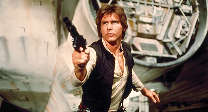 Han Solo aims a blaster in front of the Millennium Falcon from Star Wars.